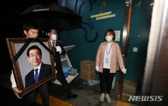 [서울=뉴시스]홍효식 기자 = 서울시 및 상조 관계자들이 13일 서울 중구 서울광장에 차려진 고 박원순 서울시장의 시민분향소를 철거한 뒤 영정사진을 들고 시민청으로 향하고 있다, 2020.07.13. yesphoto@newsis.com