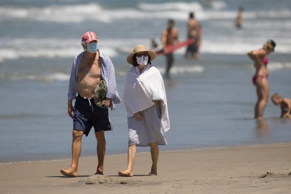 15일(현지시간) 미국 캘리포니아주 델 마 인근 해변에서 시민들이 마스크를 쓴 채 해변을 산책하고 있다. 이날 미국의 코로나19 누적사망자는 14만명을 웃돌았고 캘리포니아주 신규 확진자 수도 역대 최고치를 기록했다. 로이터뉴스1
