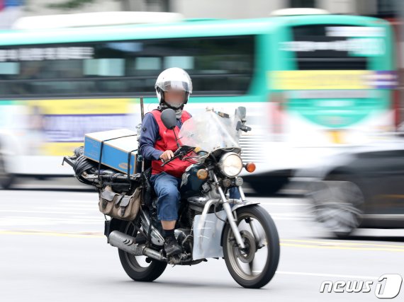 서울 종로구 세종로 사거리에 택배원이 오토바이를 몰고 물건을 나르고 있다. 뉴스1 제공