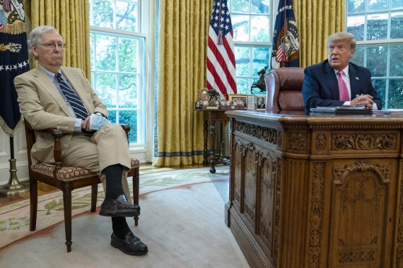 도널드 트럼프 미국 대통령(오른쪽)이 20일(현지시간) 워싱턴DC 백악관 집무실에서 공화당의 미치 매코널 상원 원내대표(켄터키주)와 이야기를 나누고 있다.AP뉴시스
