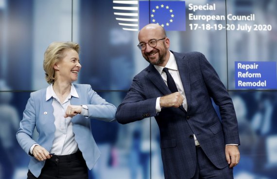 21일 벨기에 브뤼셀에서 우르줄라 폰데어라이엔 유럽연합(EU) 집행위원장(왼쪽)과 샤를 미셸 EU정상회의 의장이 코로나19 경기부양책에 대한 국가 간 합의를 이끌어낸 뒤 팔꿈치를 부딪치며 축하하고 있다. 로이터