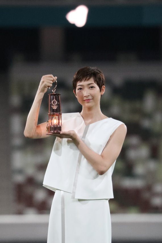 일본 여자 수영 간판스타 이케에 리카코가 도쿄올림픽 개최 1년을 앞둔 지난해 7월 23일 국립경기장에 성화가 든 랜턴을 들고 나와 희망의 메시지를 전하고 있다. 로이터 뉴스1