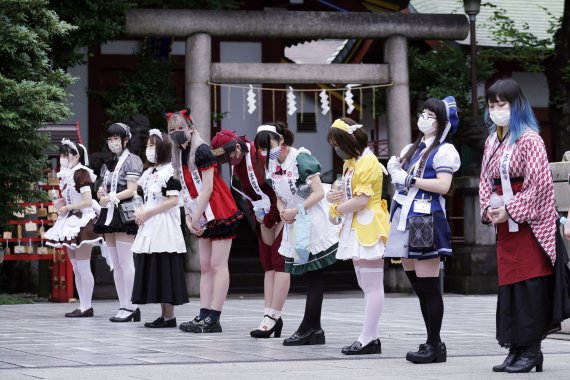 25일 도쿄 간다 묘진신사에서 코로나19로부터 안전과 사업 번창에 관한 기도회가 열렸다. 인근 아키하바라 메이드 카페의 직원들로 보이는 사람들이 경내에 줄지어 서있다. AP뉴시스
