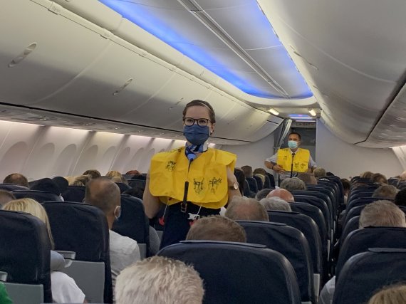 지난 6월15일(현지시간) 마스크를 착용한 TUI플라이 항공의 승무원들이 독일 뒤셀도르프에서 스페인 마요르카로 출발하기에 앞서 승객들에게 지킬 사항들을 알리고 있다.로이터뉴스1