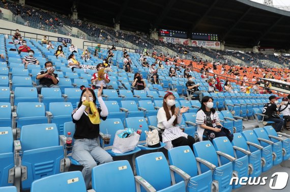 신종 코로나바이러스 감염증(코로나19) 사태로 닫혔던 관중석 출입구가 열렸다. 프로야구 관중 입장 첫 날인 26일 서울 잠실야구장에서 열린 KBO리그 두산과 LG의 경기를 찾은 야구팬들이 관중석에 띄엄띄엄 앉아 열띤 응원을 하고 있다. 2020.7.26/뉴스1 © News1 박지혜 기자