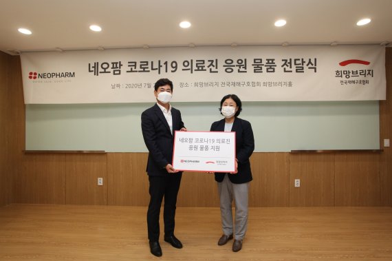 네오팜 김양수 대표 이사(왼쪽)와 희망브리지 전국재해구호협회 김정희 사무총장이 27일 기부물품 전달식에서 기념촬영을 하고 있다. 네오팜제공