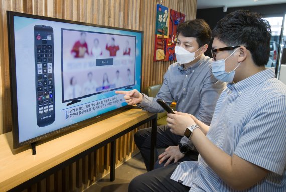 삼성전자 상품전략팀 직원(왼쪽)이 서울 관악구에 위치한 실로암 시각장애인 복지관에서 한 시각장애인에게 삼성전자 스마트TV의 접근성 기능에 대해 설명하고 있다.