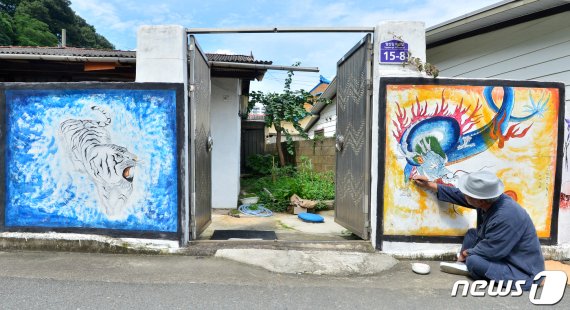초충도(草蟲圖) 명인 이철우 화백이 31일 오후 경북 포항시 북구 용흥동 주택가 벽에 호랑이와 용 벽화를 그리고 있다. 2020.7.31/뉴스1 © News1 최창호 기자