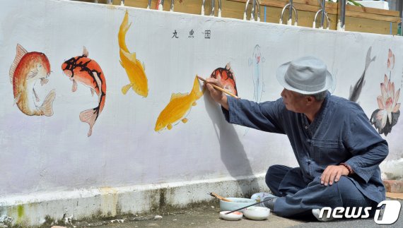 초충도(草蟲圖) 명인 이철우 화백이 31일 오후 경북 포항시 북구 용흥동 주택가 벽에 물고기 벽화를 그리고 있다. 2020.7.31/뉴스1 © News1 최창호 기자