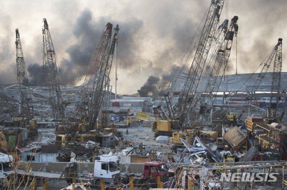 4일(현지시간) 레바논 수도 베이루트 항구에서 대규모 폭발사고가 일어나 처참하게 파괴된 현장에서 연기가 피어오르고 있다. AP뉴시스
