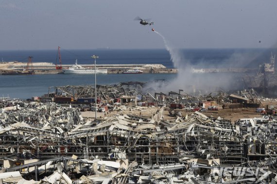 [베이루트=AP/뉴시스]5일(현지시간) 레바논 베이루트 항구 대규모 폭발 현장에서 레바논군 헬기 한 대가 물을 뿌리고 있다. 이번 대폭발로 지금까지 최소 100명이 숨지고 4000명 이상이 다친 것으로 알려졌다. 정확한 폭발 원인이 밝혀지지 않은 가운데 항구 창고에 6년간 보관했던 질산암모늄 2750t이 큰 폭발을 일으킨 것으로 보고 있다. 이번 대참사에 세계 각국이 지원과 연대 의사를 표명했다. 2020.08.05.