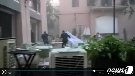 4일 레바논 베이루트 폭발 현장 인근에서 웨딩 비디오를 찍던 신부 이사라 세블라니(29)가 남편과 함께 황급히 탈출하고 있다. © 로이터=뉴스1
