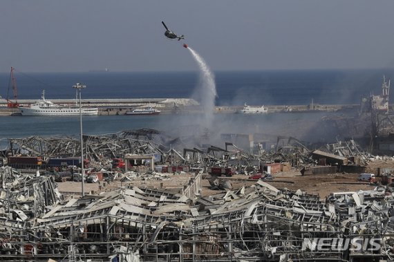 [베이루트=AP/뉴시스] 레바논 베이루트 항구에서 폭발사건이 발생한 다음 날인 5일(현지시간) 비행기 한 대가 불을 끄기 위해 물을 뿌리고 있다. 2020.08.06