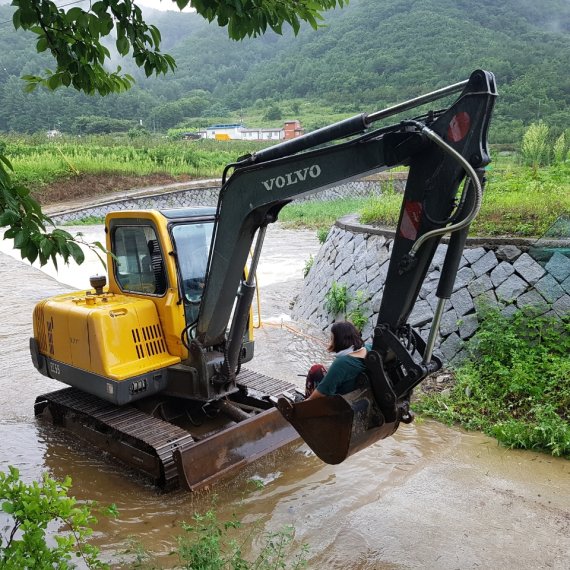 8일 오전 9시20분께 청송군 부동면 한 도로가 폭우로 침수되면서 고립된 주민을 굴삭기로 긴급 구조하고 있다. 사진=경북소방본부 제공