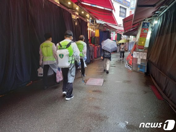 구청 직원들이 코로나19 확진자가 발생한 서울 남대문시장 케네디상가 인근 상점들을 방역하고 있다. 2020.8.10/뉴스1 © News1 이밝음 기자