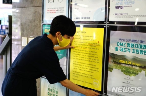 류호정 의원이 10일 국회 의원회관에 ‘비동의강간죄’에 대해 설명하는 포스터를 붙이고 있다