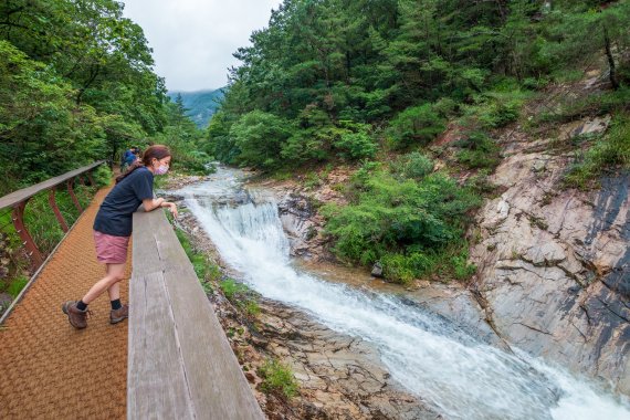 한 여행객이 수통골로 이어진 데크에서 계곡을 감상하고 있다. 비가 내린 후 수량이 불어 물소리가 힘차다. 사진=조용철 기자