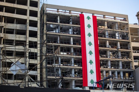 [베이루트=AP/뉴시스]12일(현지시간) 레바논 베이루트에서 폭발 참사로 훼손된 건물에 레바논 국기 모양의 배너가 걸려 있는 모습. 2020.80.16.