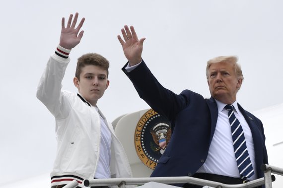 도널드 트럼프 미국 대통령(오른쪽)이 16일(현지시간) 뉴저지주 모리스타운에서 막내 아들 배런 트럼프와 함께 전용기에 타면서 손을 흔들고 있다.AP뉴시스