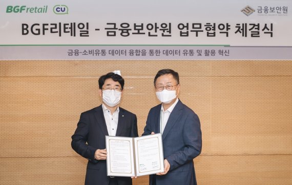 이건준 BGF리테일 사장(오른쪽)과 김영기 금융보안원장이 협약식을 마친 후 기념촬영을 하고 있다. BGF리테일 제공