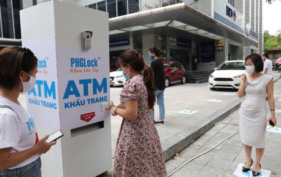 베트남 하노이 시민이 하노이에 설치된 무료 마스크 ATM에서 마스크를 받고 있다. 사진=베트남 매체 VN익스플로러