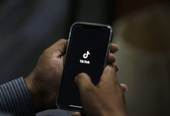 한 남자가 지난달 21일(현지시간) 파키스탄 이슬라마바드에서 휴대폰으로 틱톡 앱을 켜고 있다. 월마트는 27일 MS와 공동으로 틱톡 인수를 추진하고 있다고 밝혔다. AP뉴시스
