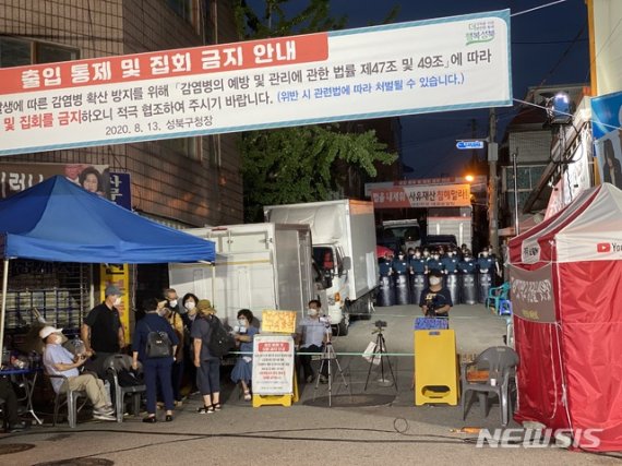 지난 21일 경찰이 서울 성북구 사랑제일교회를 압수수색하고 있는 동안 교인들이 대화를 나누고 있다. 뉴시스 제공
