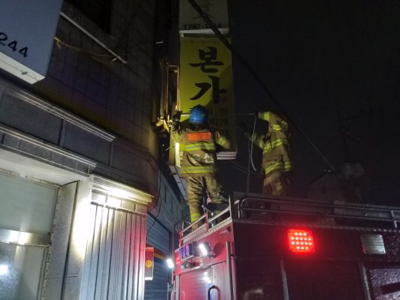 3일 새벽 3시께 울산 북구 양정동에서 태풍으로 간판이 떨어질 것 같다는 신고가 접수돼 출동한 소관이 간판을 안전하게 떼어내고 있다. /사진=울산소방본부 제공