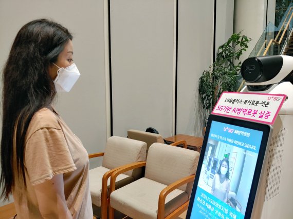 5G기반 AI방역로봇이 LG유플러스 직원의 체온과 마스크 착용상태를 점검하고 있다.(LG유플러스 제공)