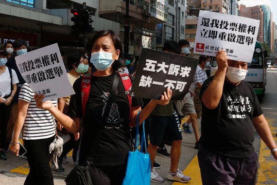 지난 6일 홍콩 입법회의 선거 1년 연기에 항의하는 시위에서 시민들이 구호를 들고 행진하고 있다. 당초 이날 예정됐던 선거는 코로나19를 이유로 1년뒤로 미뤄졌다.로이터뉴스1