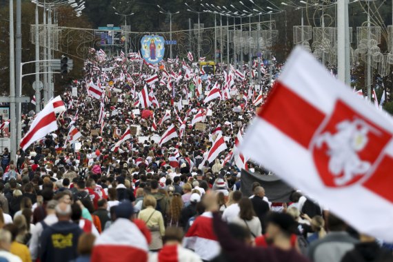 6일(현지시간) 벨라루스 민스크에서 옛 국기를 든 반정부 시위대가 행진하고 있다.AP뉴시스