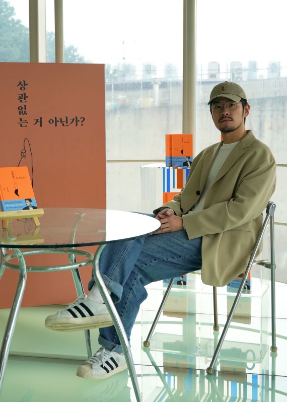 생애 첫 산문집 '상관없는 거 아닌가?'를 낸 뮤지션 장기하가 9일 경기도 파주출판단지 문학동네 사옥에 세워진 자신의 책표지 배너 앞에서 사진을 찍고 있다. / 사진=문학동네