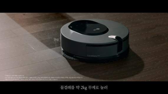 LG 코드제로 M9 씽큐가 약 2kg의 하중으로 물걸레를 눌러주며 바닥을 닦고 있는 광고 속 모습. /LG전자