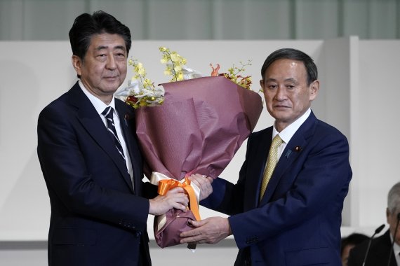 스가 요시히데 자민당 총재가 지난 14일 총재 선거에서 당선 직후 아베 신조 일본 총리와 기념촬영을 하고 있다. AP뉴시스