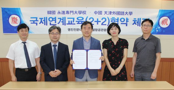 영진전문대 호텔항공관광계열이 최근 중국 톈진외국어대와 2+2연계교육 협약을 체결하고 관계자들이 기념촬영하고 있다. 사진=영진전문대 제공