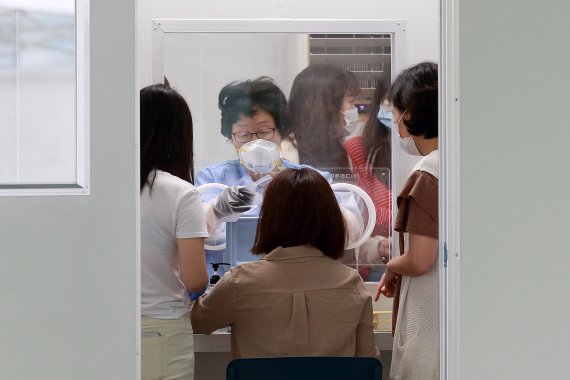 인천 남동구가 설치한 비접촉식 선별진료소에서 사람들이 섬체검사를 받고 있다.