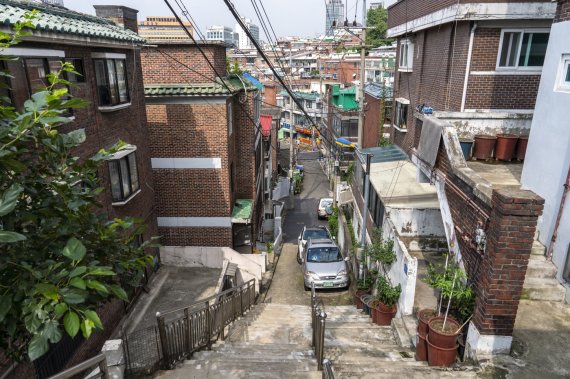 아현동 고갯길. 영화 '기생충'에 등장하는 우리슈퍼 옆 계단을 위에서 내려다본 풍경. 계단 아래 오른쪽 모퉁이에 실제의 돼지쌀슈퍼가 있다. 서울관광재단 제공