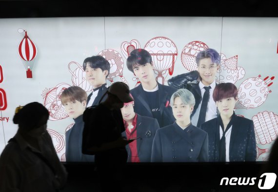 서울 중구 롯데면세점에 BTS의 광고판 앞으로 시민들이 지나가고 있다.