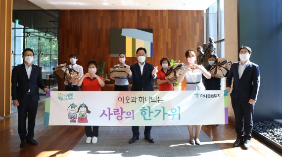 이진국 하나금융투자 사장(앞줄 가운데)이 28일 서울 여의도 하나금융투자 본사에서 빌딩 근로자 및 직원들과 '이웃과 하나되는 사랑의 한가위' 행사를 마치고 기념촬영을 하고 있다. 하나금융투자 제공