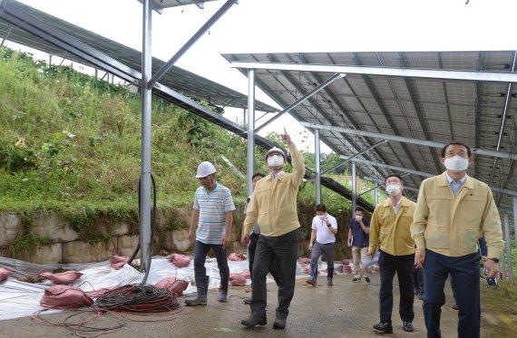 성윤모 산업통상자원부 장관(왼쪽 두번째) 이 지난 8월 집중호우로 피해를 입은 충남 천안시의 한 태양광발전 시설을 점검하고있다. 산업통상자원부 제공