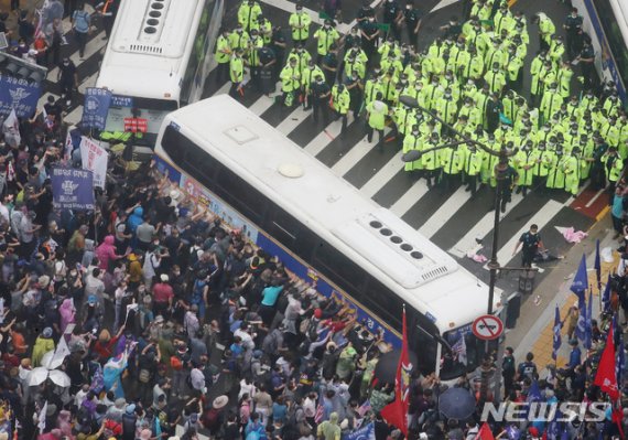 [서울=뉴시스]김명원 기자 = 15일 서울 종로구 광화문 광장 열린 보수단체 8·15 대규모 집회 참가자들이 경찰 저지선을 뚫고 사직로에서 청와대로 가는길로 몰려와 경찰들과 대치하고 있는 가운데 일부 집회 참가자들이 경찰 버스를 넘어트리려는 듯 밀고 있다. 2020.08.15. kmx1105@newsis.com