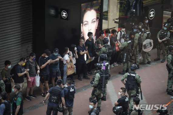 [홍콩=AP/뉴시스]홍콩 경찰이 중국 국경절인 1일 코즈웨이베이에서 보행자를 검문하고 있다. 홍콩 경찰은 1일 신종 코로나바이러스 감염증(코로나19)으로 대규모 집회가 금지됐음에도 불구하고 중국 국경절을 맞아 민주화 구호를 외치며 거리에 몰려든 최소 60명의 시위대원들을 불법 집회 혐의로 체포했다. 2020.10.1