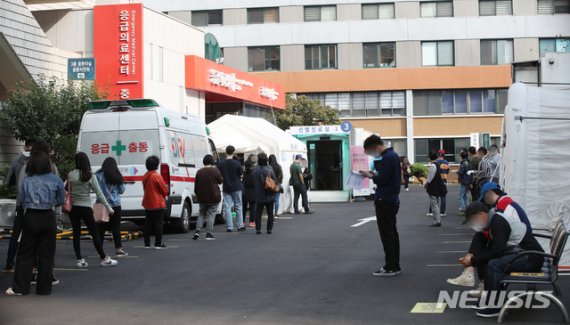 추석을 하루 앞둔 지난달 30일 오전 서울 중구 국립중앙의료원 코로나19 선별진료소에서 시민과 해외출국예정자 등이 검사를 받기 위해 줄서 기다리고 있다.