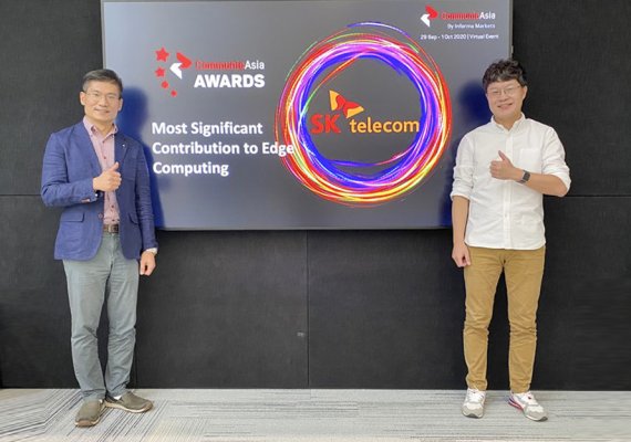5GX Cloud Labs의 이동기 PL(오른쪽)과 신상호 매니저가 지난달 30일 '커뮤닉 아시아 어워드 2020' 수상 화면 앞에서 기념 촬영을 하고 있다.