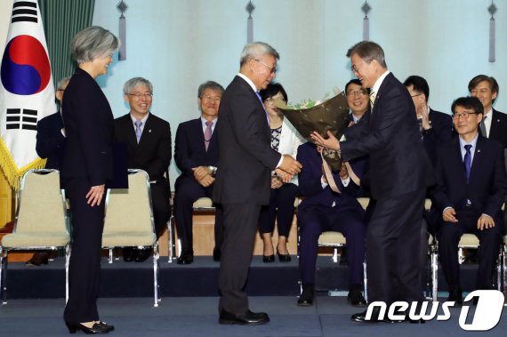 문재인 대통령이 2017년 6월 18일 오후 청와대에서 열린 강경화 외교부장관 임명식에서 강 장관 남편 이일병 교수에게 꽃다발을 주고 있다./사진=뉴스1