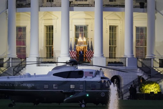 도널드 트럼프 미국 대통령이 코로나19로 입원했던 월터리드 군병원에서 퇴원한 5일(현지시간) 해병1호 헬기편으로 백악관에 도착한 후 베란다에 서있다.AP뉴시스