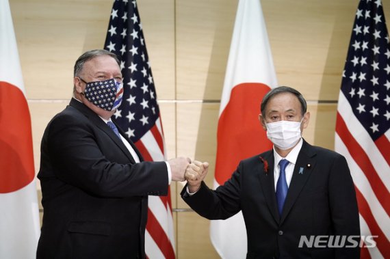 [도쿄=AP/뉴시스]일본을 방문한 마이크 폼페이오(왼쪽) 미 국무장관이 6일 일본 도쿄 총리공관에서 스가 요시히데 총리와 만나 회담에 앞서 주먹 인사를 나누고 있다. 폼페이오 장관은 스가 총리 예방 후 미국·일본·호주·인도 4개국 외교장관 회담인 '쿼드' 회의에 참석한다. 2020.10.06.