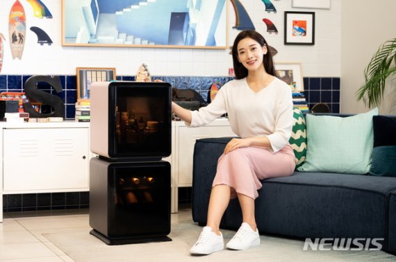 [서울=뉴시스] 삼성전자 모델이 삼성디지털프라자 강남본점 5층에 위치한 라이프스타일 쇼룸 #ProjectPRISM에서 소비자의 취향에 따라 와인, 맥주, 화장품 등을 전문적으로 보관할 수 있는 맞춤형 소형 냉장고 ‘삼성 비스포크 큐브’ 를 소개하고 있다. (제공=삼성전자)