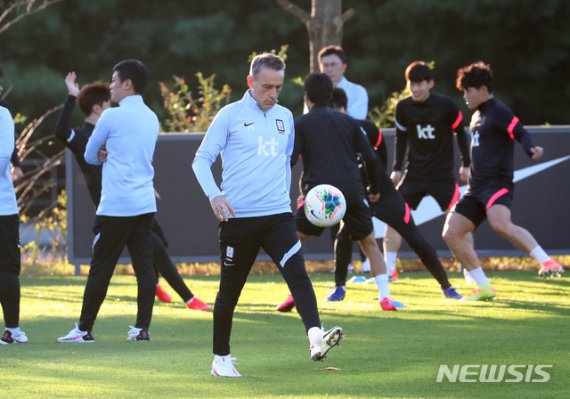 [파주=뉴시스]배훈식 기자 = 올림픽 축구 대표팀과의 친선 경기를 앞둔 파울루 벤투 국가대표팀 감독이 8일 오후 경기 파주시 파주NFC에서 훈련하는 선수들 사이에서 몸을 풀고 있다. 2020.10.08. dahora83@newsis.com