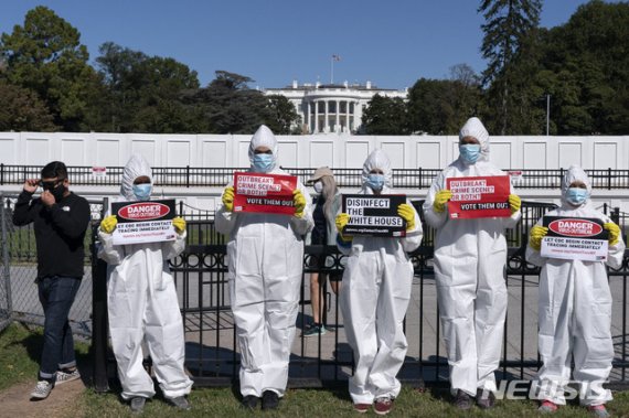 지난 8일(현지시간) 미국 백악관 앞에서 보호복과 마스크, 장갑을 착용한 시위대가 신종 코로나바이러스 감염증(코로나19)에 항의하고 벌이고 있다. /사진=뉴시스